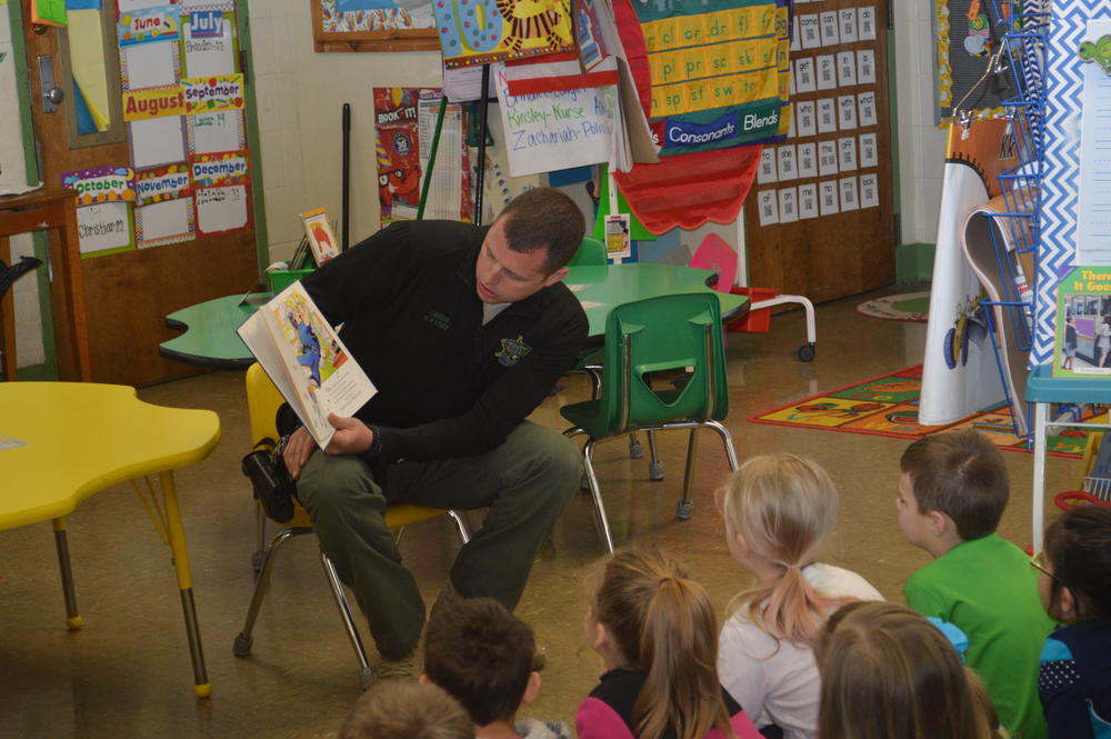 Deputy Green reading a book to kindergarten students