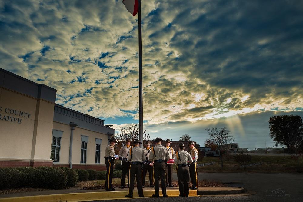 Cherokee County Sheriff's Office Honor Guard standing around the flag pole, preparing to take down the American flag